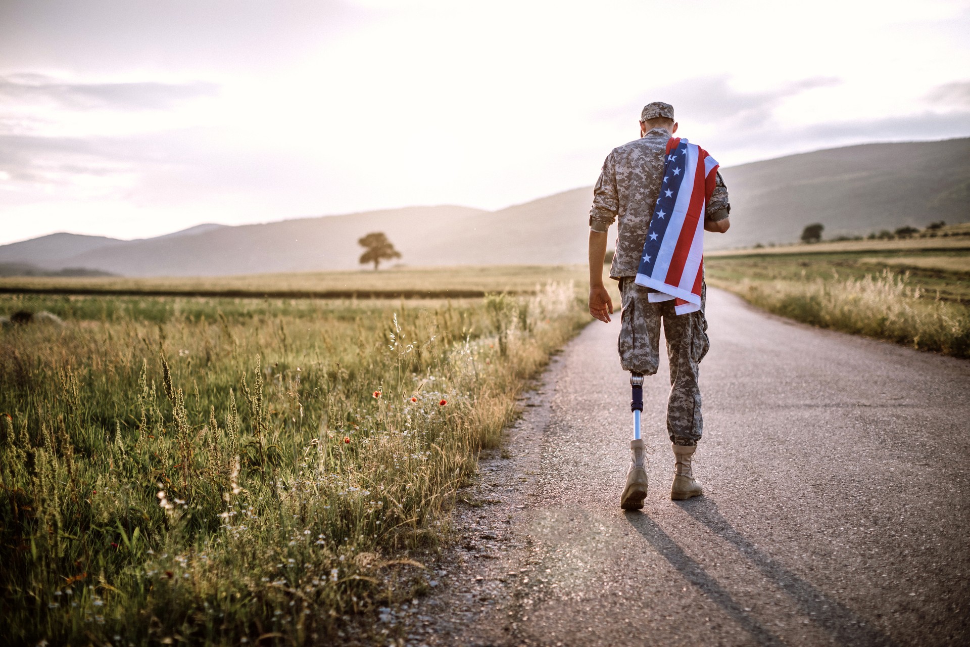 Amputee soldier with American flag on road