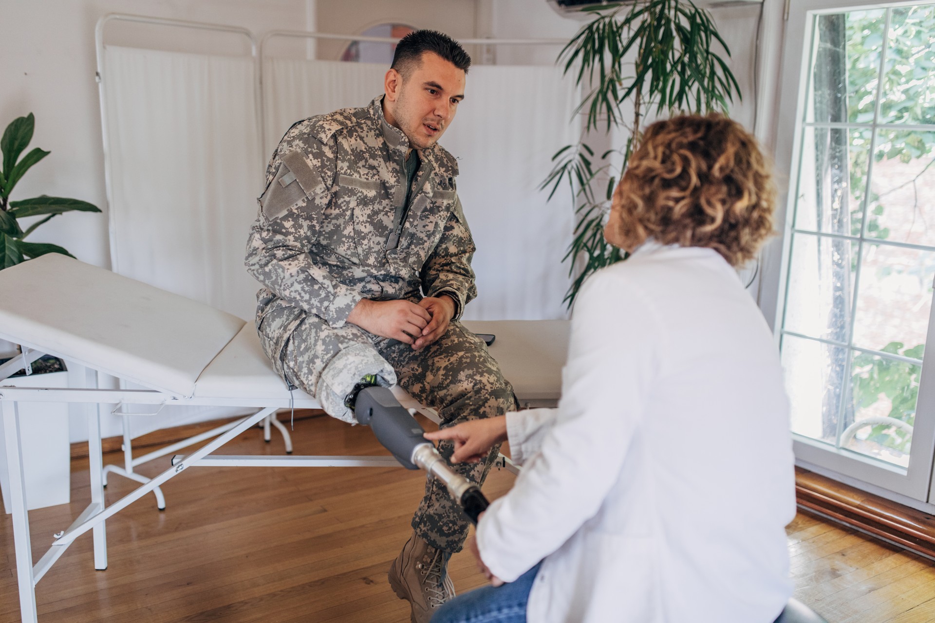 Medical professional attending to a soldier's prosthesis.